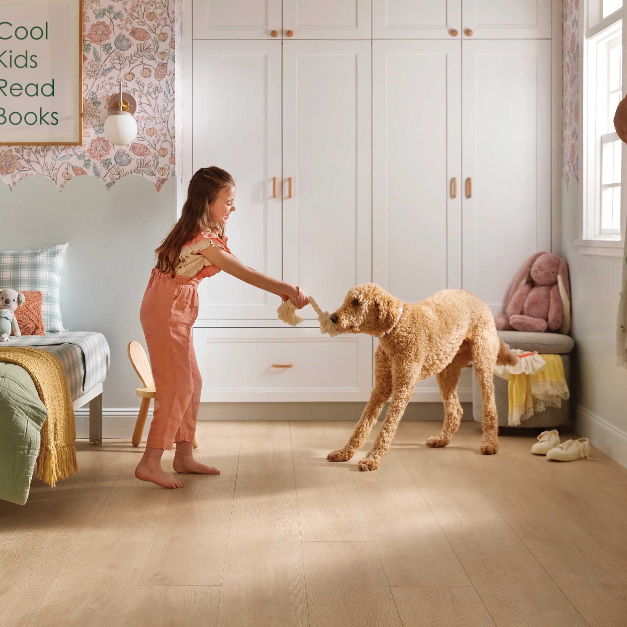 Girl playing tug of war on luxury vinyl flooring from Shaw's Pet Perfect line, available at Carpetland USA.